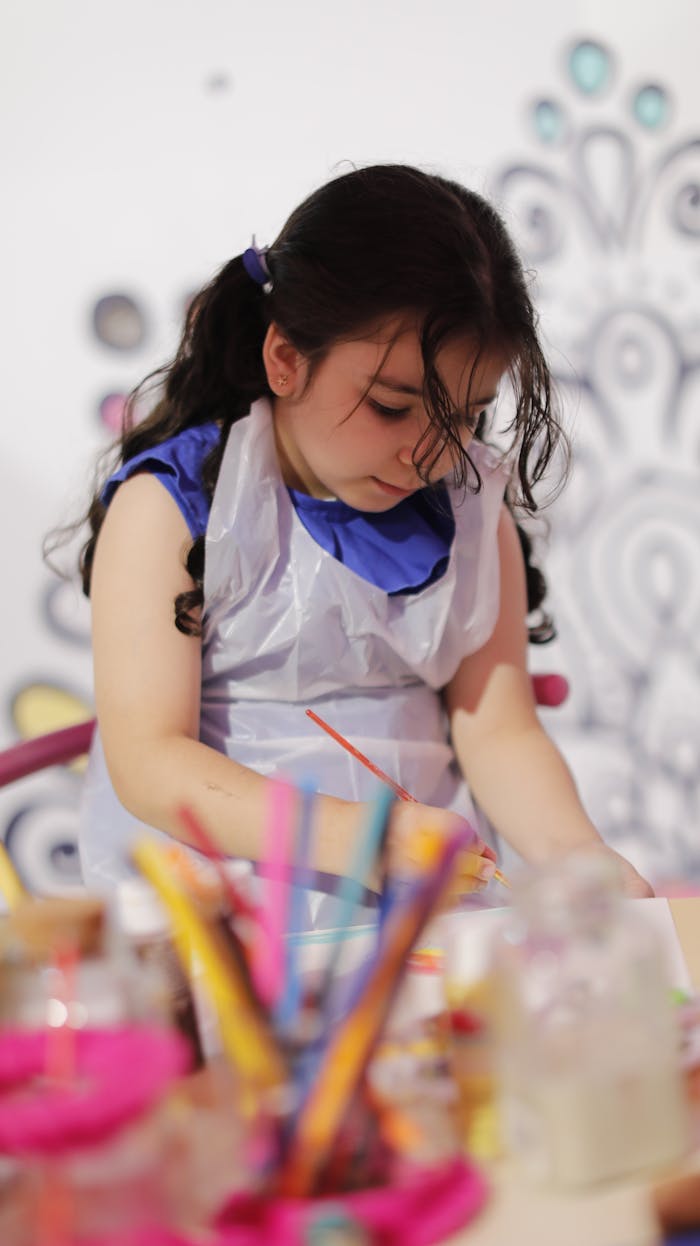 Child absorbed in painting and creativity at art class, focusing with vivid colors.